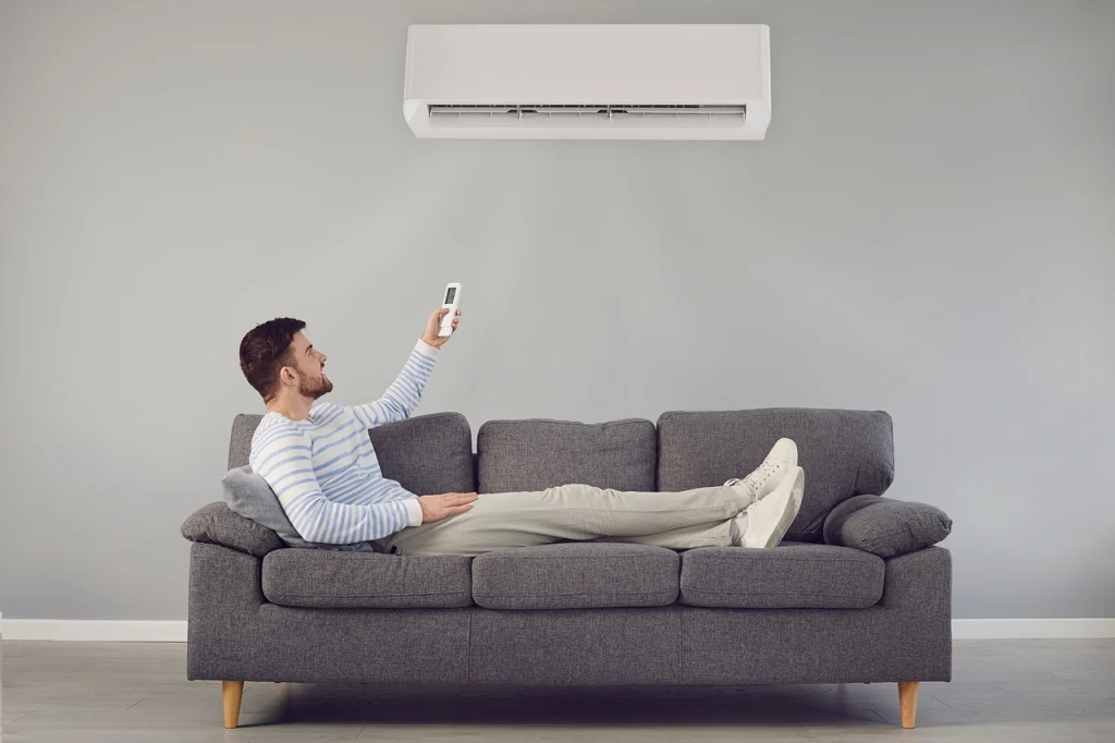 Homem relaxando no sofá com o ar condicionado ligado